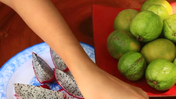 Couper et mettre des fruits exotiques frais dans l'assiette . — Video