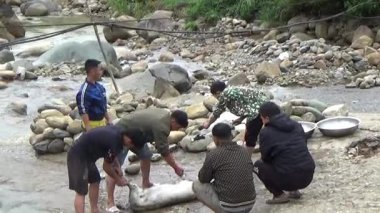 28 Ekim 2025. Mu Cang Chai, Yen Bai, Vietnam. Dağ çiftçileri derenin kıyısında domuz kesiyor.