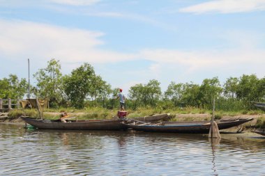 16 Eylül 2025. Pha Tam Giang, Hue, Vietnam. Doğal bir nehirde tekne gezisi. Balıkçılar teknede balık, karides, midye ızgara yapar.
