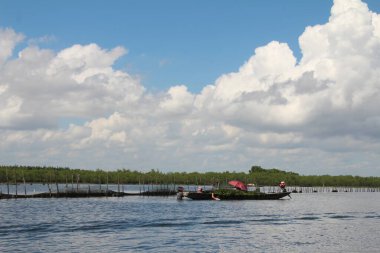 16 Eylül 2025. Pha Tam Giang, Hue, Vietnam. Doğal bir nehirde tekne gezisi. Balıkçılar teknede balık, karides, midye ızgara yapar.