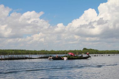 16 Eylül 2025. Pha Tam Giang, Hue, Vietnam. Doğal bir nehirde tekne gezisi. Balıkçılar teknede balık, karides, midye ızgara yapar.