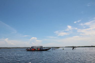 16 Eylül 2025. Pha Tam Giang, Hue, Vietnam. Doğal bir nehirde tekne gezisi. Balıkçılar teknede balık, karides, midye ızgara yapar.