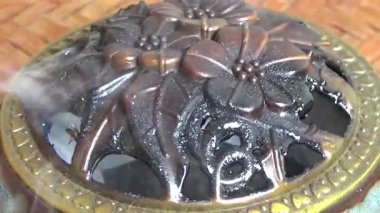 Tütsü yakan, tütsülenmiş, kalın duman çıkaran bir ocak.