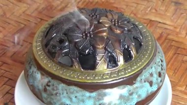 Tütsü yakan, tütsülenmiş, kalın duman çıkaran bir ocak.