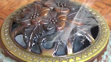 Tütsü yakan, tütsülenmiş, kalın duman çıkaran bir ocak.