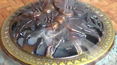 Tütsü yakan, tütsülenmiş, kalın duman çıkaran bir ocak.