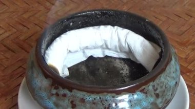 Tütsü yakan, tütsülenmiş, kalın duman çıkaran bir ocak.