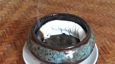 Tütsü yakan, tütsülenmiş, kalın duman çıkaran bir ocak.