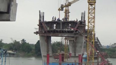 9 Şubat 2026. Chu Van An, Hai Phong, Vietnam. İşçiler nehir boyunca bir köprü inşa ediyorlar.