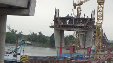 9 Şubat 2026. Chu Van An, Hai Phong, Vietnam. İşçiler nehir boyunca bir köprü inşa ediyorlar.