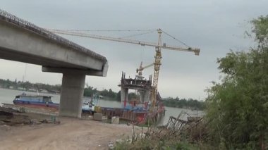 9 Şubat 2026. Chu Van An, Hai Phong, Vietnam. İşçiler nehir boyunca bir köprü inşa ediyorlar.