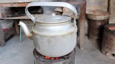 yanan kömür sobası üzerinde kaynar su ısıtıcısı