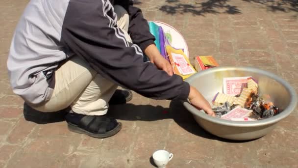 Man burning money, gold for the dead. — Stock Video