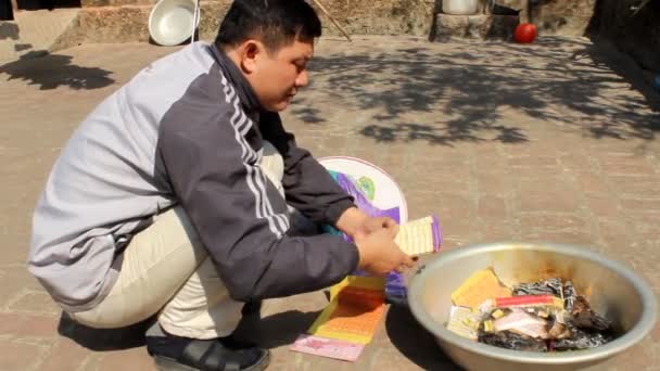 Man burning votive for the ancestors — Stock Video