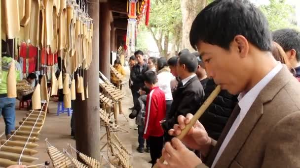 Azjatycki człowiek w tradycyjne instrumenty wykonane z bambusa na festiwal folklorystyczny — Wideo stockowe