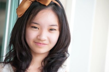 Genç Asyalı Çinli kadın gülümseyerek 