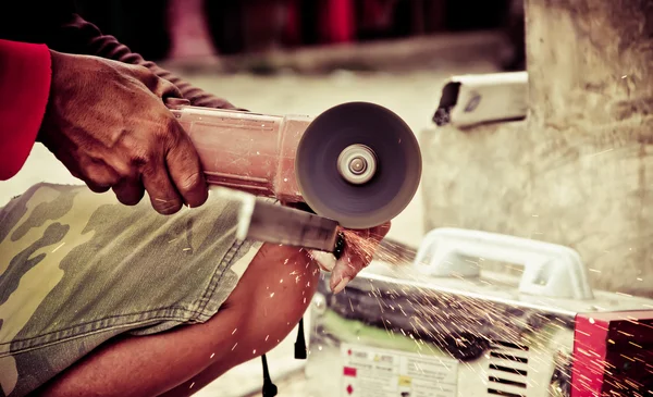 Travailleur utilisant une petite meuleuse pour couper le métal — Photo