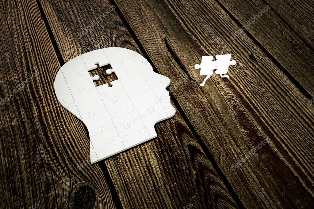 Missing jigsaw of human head build out of puzzle pieces on wood planks, with one bright piece run closer to it. Creative idea for memory loss. Amnesia disease. Mental health concept. 3d Render