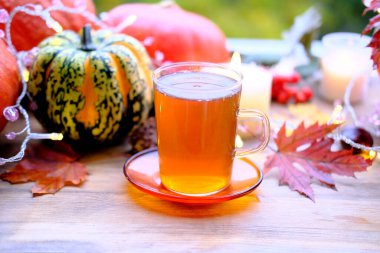 Yeşil çay bardağını kaplamalı, çay tabağının üstünde, ahşap masa üzerinde, balkabağı yalanı, mumlar yanıyor, sabah konsepti, mevsimlik sonbahar havası, sağlıklı yaşam tarzı.