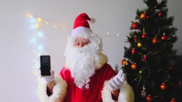 Санта Клаус Білою Бородою Вітає Дітей Дорослих Тримає Телефон Порожнім — стокове відео