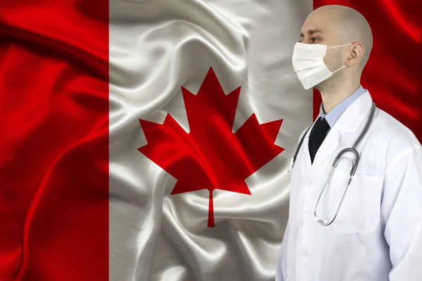 male doctor with a stethoscope on the background of the silk national flag of Canada, the concept of national medical care, health, insurance, tourism