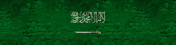 アラビア語の碑文を持つサウジアラビア王国の国旗の長いパノラマ古い石の壁 概念観光 政治にムハンマド以外には 神以外に神はありません — ストック写真