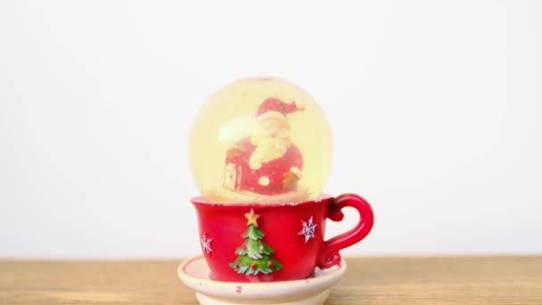 Статуэтка Санта Клауса Белой Бородой Снежном Шаре Снег Красная Чашка — стоковое видео