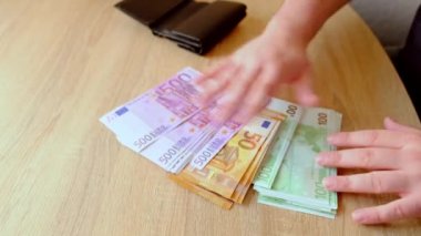 Erkek eli siyah deri cüzdandan para çeker, para sayar, para değiştirir, iş konsepti değiştirir, satın almak için nakit öder.