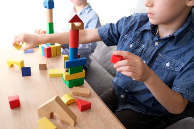 Çocuklar, çocuklar renkli ahşap figürlerden kuleler ve binalar inşa ediyorlar, konut inşaatı, konut kredisi, sigorta, mutlu çocukluk, çocuk oyunları, alfa kuşağı konsepti