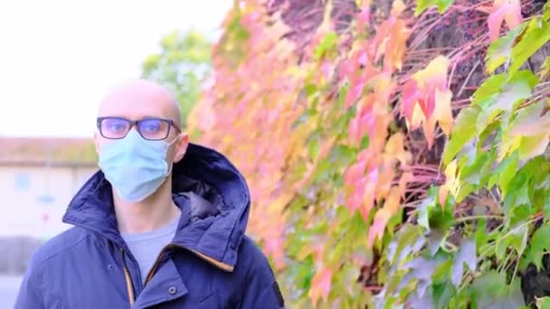 ジャケットを着た若者と医療用の白いマスクは ヨーロッパの都市の通りを歩き ビジネス旅行の概念 秋の旅行 Covid 19コロナウイルスパンデミックの期間 — ストック動画