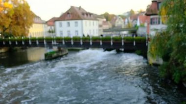 Bulanık arka plan, Avrupa 'nın Bamberg kentinin eski evleri arasında geniş bir nehir akıyor, turistler taş köprü boyunca yürüyor, seyahat kavramı, turizm