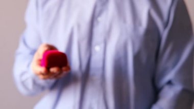 Adam elinde mücevherlerle kırmızı bir kutu tutuyor, bayram hediyesi, açıyor, tatil konsepti, evli bir çiftin yıldönümü, sevgililer günü, anne, mutlu noeller.