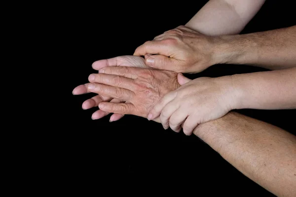 男性と女性の手を黒の背景に しわと静脈を持つ古い皮膚 健康の概念 年齢関連の変化 愛のカップルの優しい関係 孤立したイメージ — ストック写真