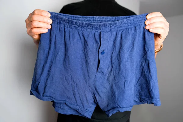 Man Met Blauwe Mannenonderbroek Zijn Handen Gebreid Ondergoed Een Concept — Stockfoto