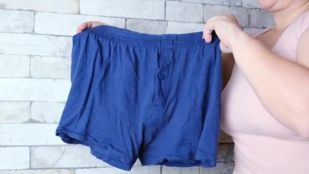 Kvinna Som Håller Blå Mäns Kalsonger Händerna Stickade Underkläder Begreppet — Stockvideo