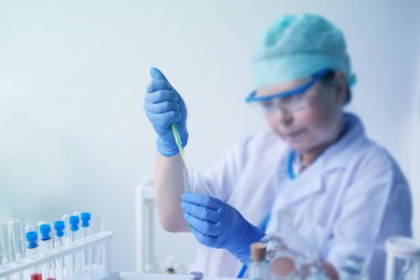 Kadın bilim adamı, laboratuvar asistanı, laboratuvarda bir DNA testi yapıyor, COVID-19 'a karşı bir aşı araştırıyor, yeni bir ilaç yaratıyor, modern bilimde bir yenilik kavramı.