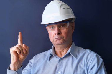 Yaşlı erkek mühendis, koruyucu kasklı müteahhit, ciddi bakan gözlükler, modern mimari konsept, gayrimenkul satın alma danışmanı