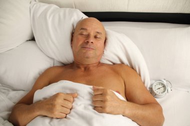 Yaşlı adam beyaz yatakta uyuyor, iş seyahati konsepti, seyahat, sağlıklı uyku, uykusuzluk, gürültü...