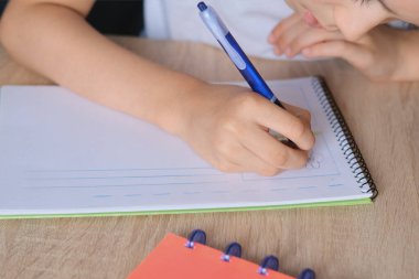 Çocuk tahtaya bir defter çizer ve yazar, okul yılının başlangıcı konsepti, ödevler, dersler, okula dönüş.