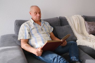 Yaşlı bir adam eski fotoğraflarla dolu bir albüme bakar, gençlik, çocukluk anıları, hayatını hatırlamak, akrabaları, nesillerin aile bağları.