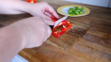 Kadın elleri ince dilimlere bölünmüş domatesler, kırmızı biberler, ahşap bir masada biberler, evde sağlıklı yemek yapma konsepti, yemek servisi.