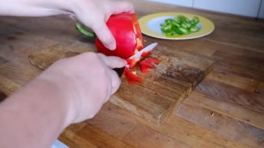Kadın elleri ince dilimlere bölünmüş domatesler, kırmızı biberler, ahşap bir masada biberler, evde sağlıklı yemek yapma konsepti, yemek servisi.