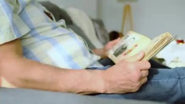 Yaşlı bir adam 1960-1965 yılları arasındaki eski fotoğraflarıyla bir albüme bakıyor, gençlik, çocukluk anıları, hayatını hatırlamak, akrabaları, nesillerin aile bağları.