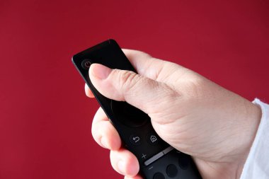 Kadın eli uzaktan kumanda, TV kumandası, müzik aletlerinin düğmesine basıyor, modern teknoloji kavramına.