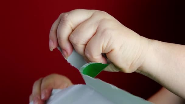 Mão Feminina Rasgando Livro Verde Fundo Vermelho Conceito Embalagem Presente — Vídeo de Stock