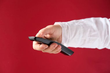 Kadın eli uzaktan kumanda, TV kumandası, müzik aletlerinin düğmesine basıyor, modern teknoloji kavramı, kontrol mekanizması