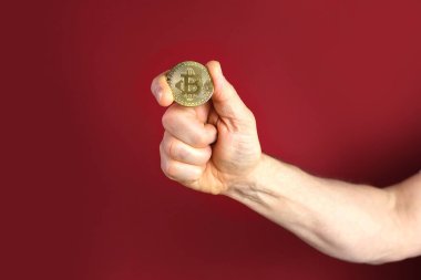 Erkek eli, kırmızı arka planda altın sikke tutar, satış grafikleri, yukarı ve aşağı konsept, bankacılık, tasarruf parası, ödemeler, e-ticaret