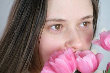 Genç bir kadın, uzun sarı saçlı bir buket pembe lale elinde bir buket pembe lale, kavram baharı, anneler günü, sevgililer günü, doğum günü, tatil