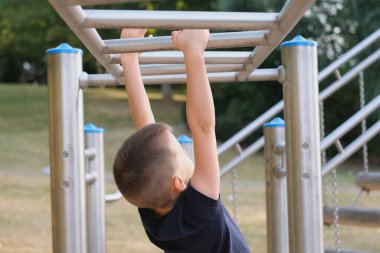 Çocuk, çocuk oyun parkında, dikiz aynasında, fiziksel aktivite konseptinde, çocuk sporlarında, dengede yürüyor.