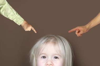 Küçük sarışın kızın yüzünün bir kısmı koyu arka planda, kahverengi gözlere bak, erkek ve kadın elleri çocuğu suçla, çocuk masumiyeti, yetiştirme, çocukluk, psikoloji şiddeti
